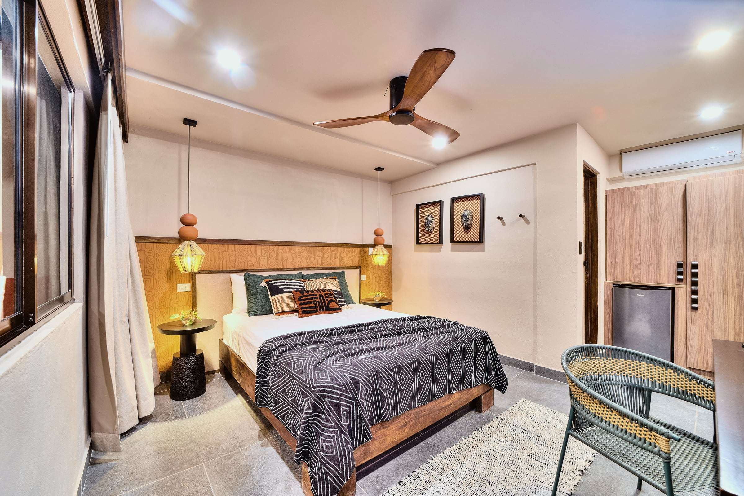 Superior Garden Room: queen bed with a geometric throw, woven pendant lamps, ceiling fan and a green woven armchair