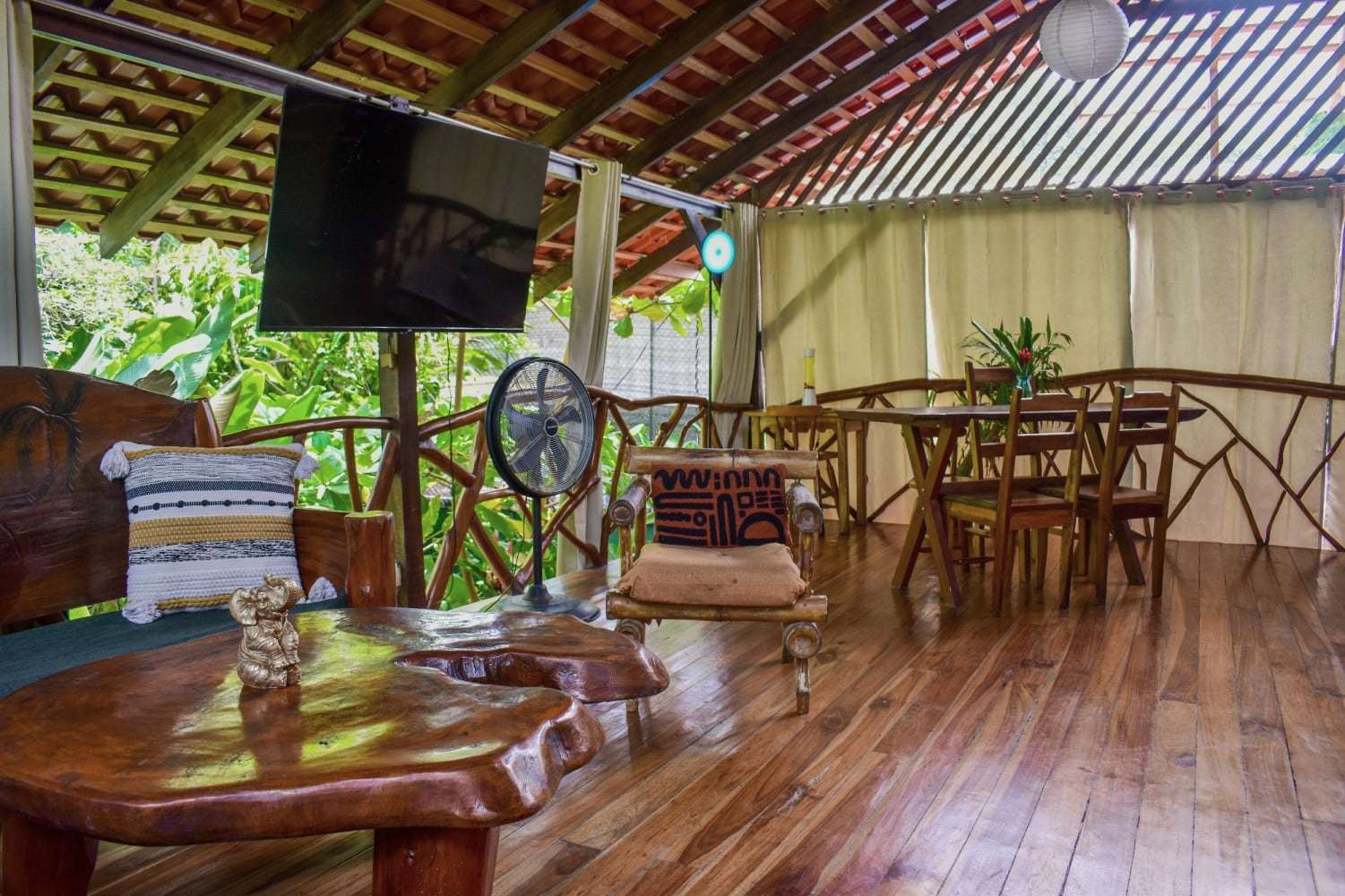 Garden Home living area with a live-edge coffee table and log armchair, opening onto the dining table